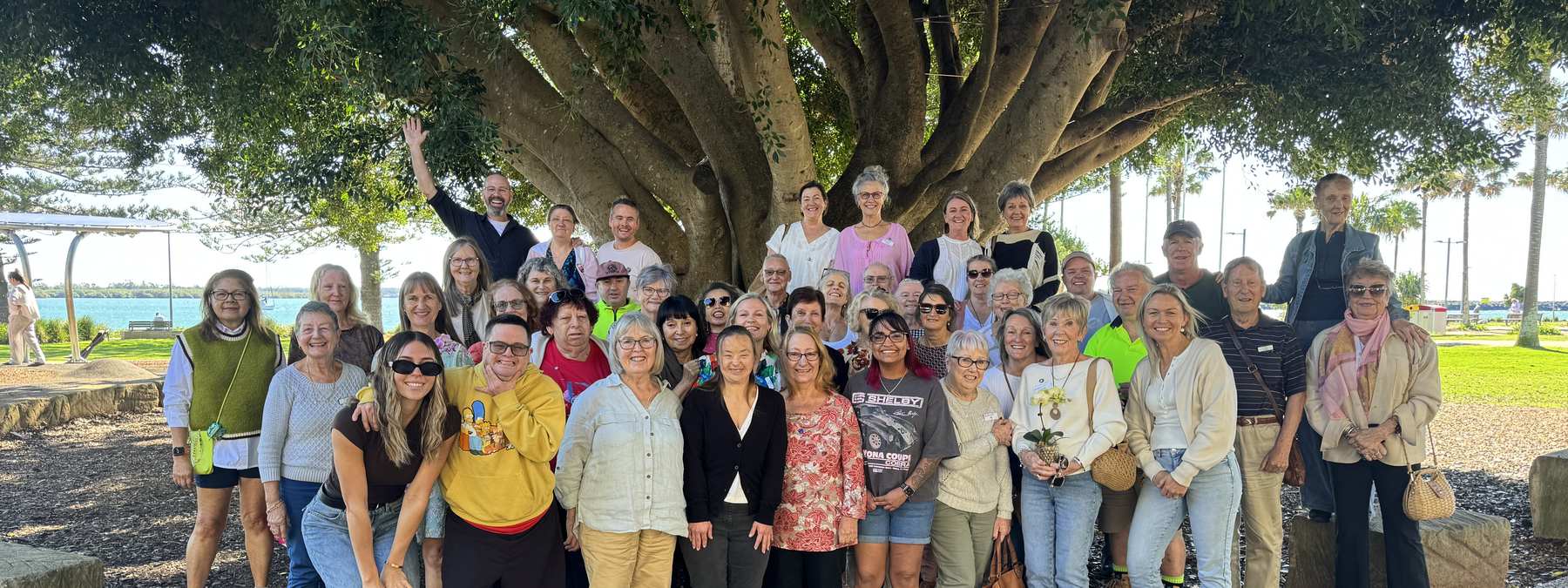 Lifeline Mid Coast volunteers in Port Macquarie, gathered under the fig trees by the water